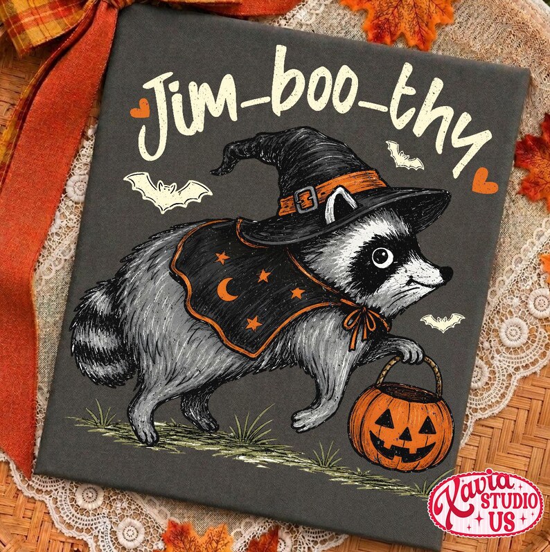 May include: A rectangular black canvas print featuring a gray raccoon wearing a black witch hat and a black cape with orange stars and a crescent moon. The raccoon holds an orange jack-o'-lantern bucket. The text Jim-boo-thy is printed above.