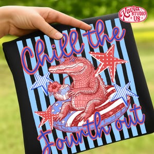 May include: Black t-shirt with a Fourth of July design. The graphic features a red alligator wearing sunglasses and floating on an inner tube. The text reads "Chill the Fourth out" in blue and red.