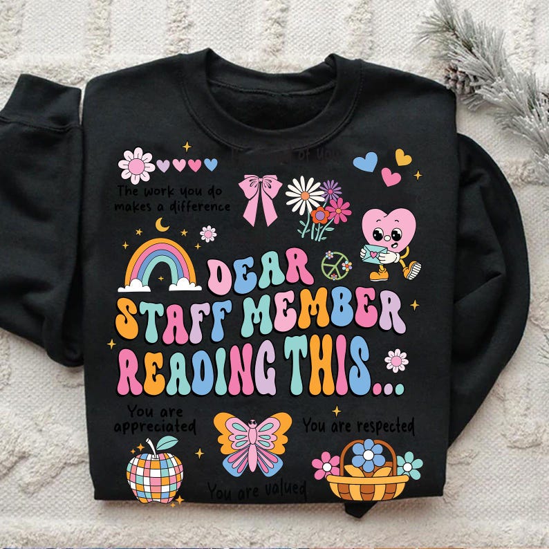 May include: Black sweatshirt with a rainbow, flowers, and a heart design. The text reads "Dear Staff Member Reading This... You are appreciated. You are respected. You are valued."