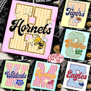 May include: A collection of six rectangular signs featuring large varsity-style letters with a gingham pattern, gold glitter outlines, and star accents. Each sign displays a team name in cursive script and a corresponding mascot illustration.