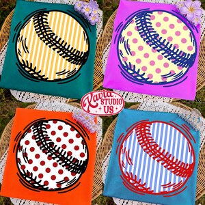 May include: Four colorful t-shirts with baseball designs. Each shirt features a baseball graphic with different patterns: yellow stripes, pink polka dots, red polka dots, and blue and white stripes. The shirts are on a wicker surface.