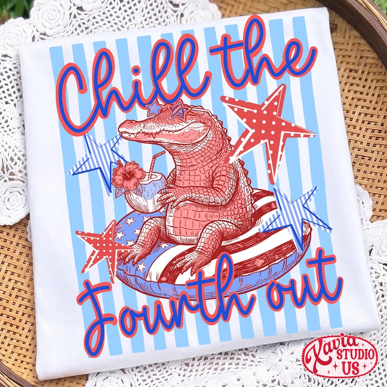 May include: White t-shirt with a patriotic design. The shirt features a red alligator wearing star-shaped sunglasses, relaxing on a float with red, white, and blue stripes. Text reads "Chill the Fourth out" in red and blue.