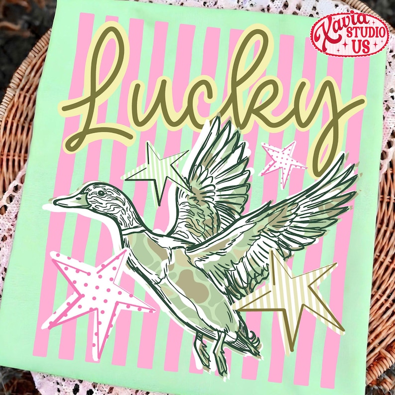 May include: A light green fabric with pink vertical stripes and the word "Lucky" in a cursive font. A duck illustration with outstretched wings is surrounded by star shapes. The image includes the text "Lavia Studio + US".