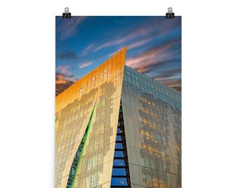 May include: A modern building with a gold and green patterned facade against a cloudy sunset sky.