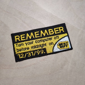 May include: A black and yellow embroidered patch with the text "REMEMBER Turn your computer off before midnight on 12/31/99." and a white and yellow Best Buy logo.