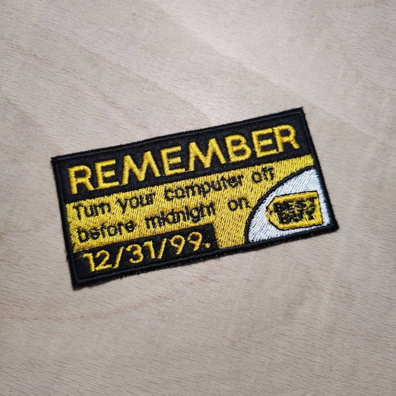 May include: A black and yellow embroidered patch with the text "REMEMBER Turn your computer off before midnight on 12/31/99." and a white and yellow Best Buy logo.