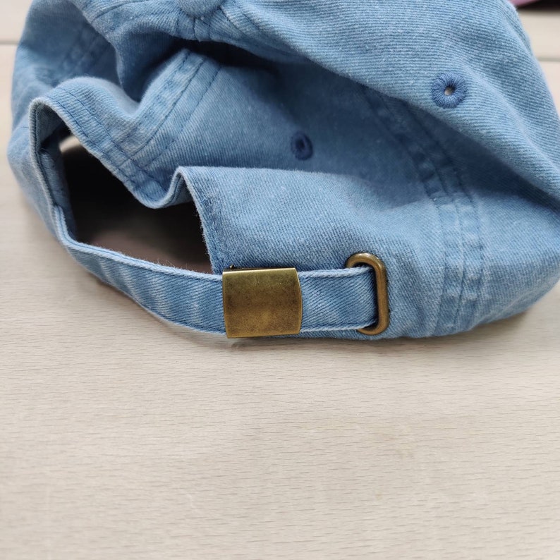 K&ouml;nnte beinhalten: Eine hellblaue Baseballkappe aus Denim mit einem Messingverschluss.