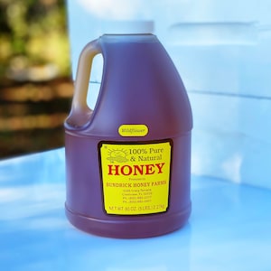 May include: A gallon jug of wildflower honey with a yellow label that reads "100% Pure & Natural Honey" and "Bundrick Honey Farms".