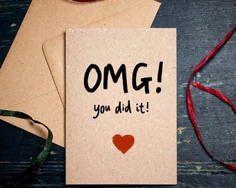 May include: A brown card with the text "OMG! You did it!" written in black marker. A red heart is drawn below the text.