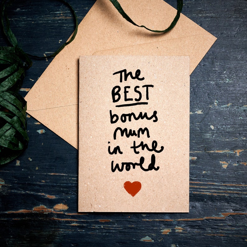 May include: A brown card with the text "The Best Bonus Mum in the World" written in black marker. A red heart is drawn below the text.