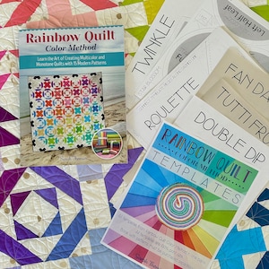 Może przedstawiać: Zbiór szablonów do patchworku i książka zatytułowana "Rainbow Quilt Color Method" autorstwa Sarah Thomas. Książka uczy, jak tworzyć wielokolorowe i jednokolorowe patchworki z 15 nowoczesnymi wzorami. Szablony są do różnych bloków patchworkowych, w tym gwiazdy, ruletki i podwójnego zanurzenia.