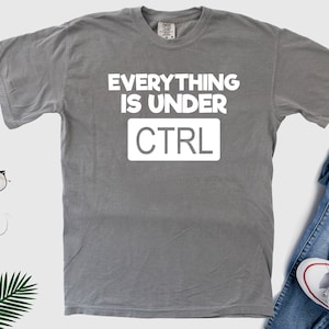 May include: Gray t-shirt with white text that reads "Everything is under CTRL".