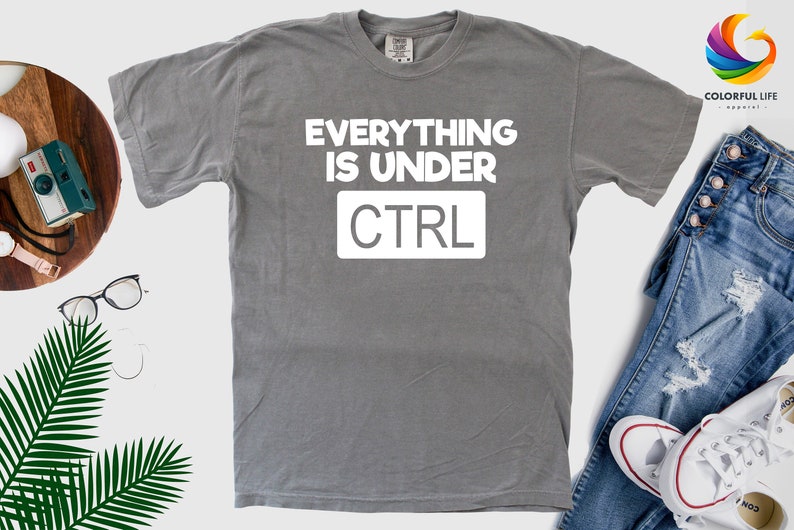 May include: Gray t-shirt with white text that reads "Everything is under CTRL".