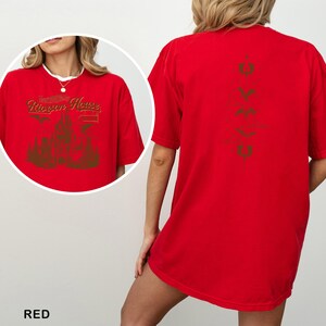 May include: A red t-shirt with a gold graphic on the front that says "Rierson House" above a castle design. The back of the shirt has a vertical gold design. The word "RED" is at the bottom of the image.