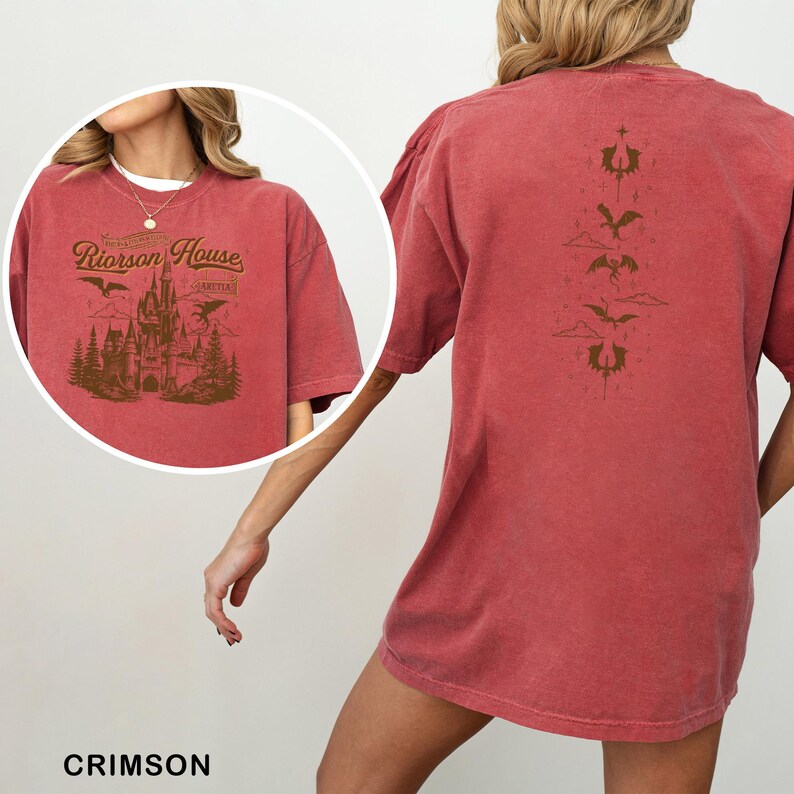 May include: Crimson-colored t-shirt featuring a graphic of a castle with the text "Rioroson House" on the front. The back of the shirt has a series of stylized dragon and cloud designs. The shirt is a comfortable, oversized fit.