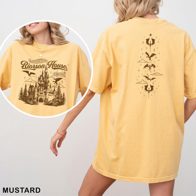 May include: Mustard-colored t-shirt featuring a detailed graphic of a castle with the text "Riorrson House" and "Aretia". The back of the shirt displays a series of dragon illustrations. The shirt is a relaxed fit.