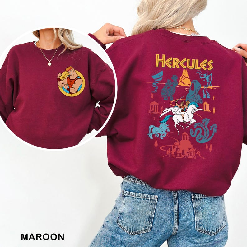 K&ouml;nnte beinhalten: Burgunderfarbenes Sweatshirt mit einer Cartoon-Grafik von Herkules auf der Vorderseite und einem gr&ouml;&szlig;eren Herkules-Motiv auf der R&uuml;ckseite. Das R&uuml;ckendesign enth&auml;lt das Wort "Hercules" in Gelb sowie verschiedene Zeichentrickfiguren und Elemente aus dem Film. Das Sweatshirt hat eine einfarbige Burgunderfarbe.