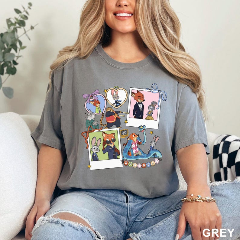 May include: Grey t-shirt with cartoon characters from Zootropolis. The design includes framed images of the characters, with the word "Zootopia" in a circle. The shirt is made of a soft material.