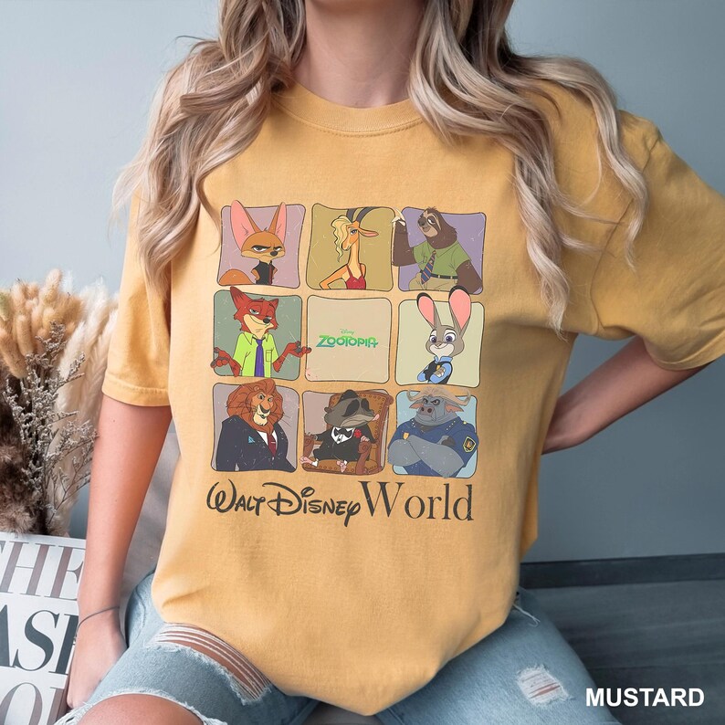 May include: Mustard-colored t-shirt featuring a grid of Zootopia characters. The shirt includes the text "Zootopia" and "Walt Disney World" in a vintage style. The shirt is a comfortable fit.