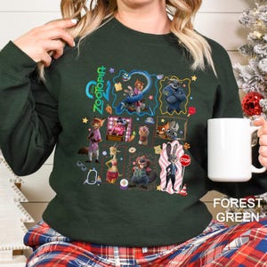 May include: Forest green sweatshirt with a colourful collage of Zootopia characters. The design includes the film's logo and illustrations of various characters arranged in a grid.