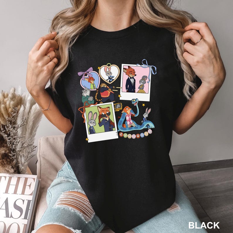 May include: Black crew neck t-shirt with colourful cartoon images of Zootopia characters. The graphic includes Nick Wilde, Judy Hopps, and other characters in various poses. The word "BLACK" is printed at the bottom right of the t-shirt.