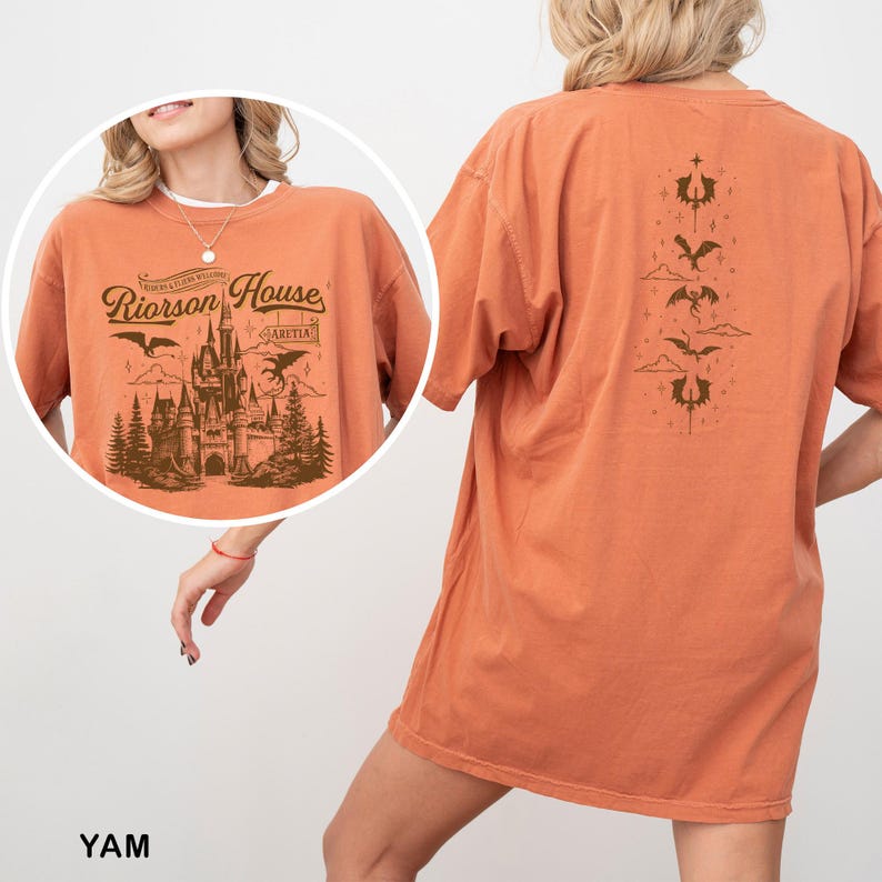 May include: Orange t-shirt with a graphic of a castle, dragons, and the text "Riorrson House" on the front. The back of the shirt features a vertical design with dragons and decorative elements. The shirt is a comfortable, oversized fit.