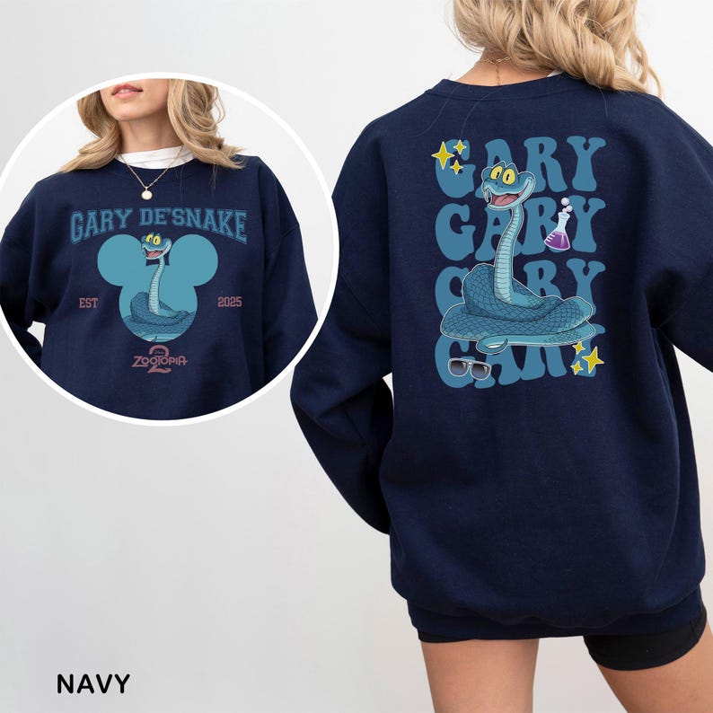 May include: Navy blue sweatshirt featuring a cartoon snake character with the text "GARY DE'SNAKE" and "ZOOTOPIA" on the front. The back of the sweatshirt has a vertical design with the name "GARY" repeated and the snake character. The sweatshirt has a crew neck.