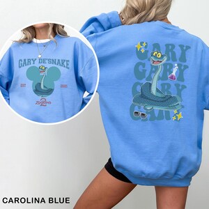 May include: Carolina blue sweatshirt featuring a cartoon snake character with the text "GARY DE'SNAKE" and "ZODORIA 2". The back of the sweatshirt has a larger graphic of the snake with the text "GARY" repeated vertically.