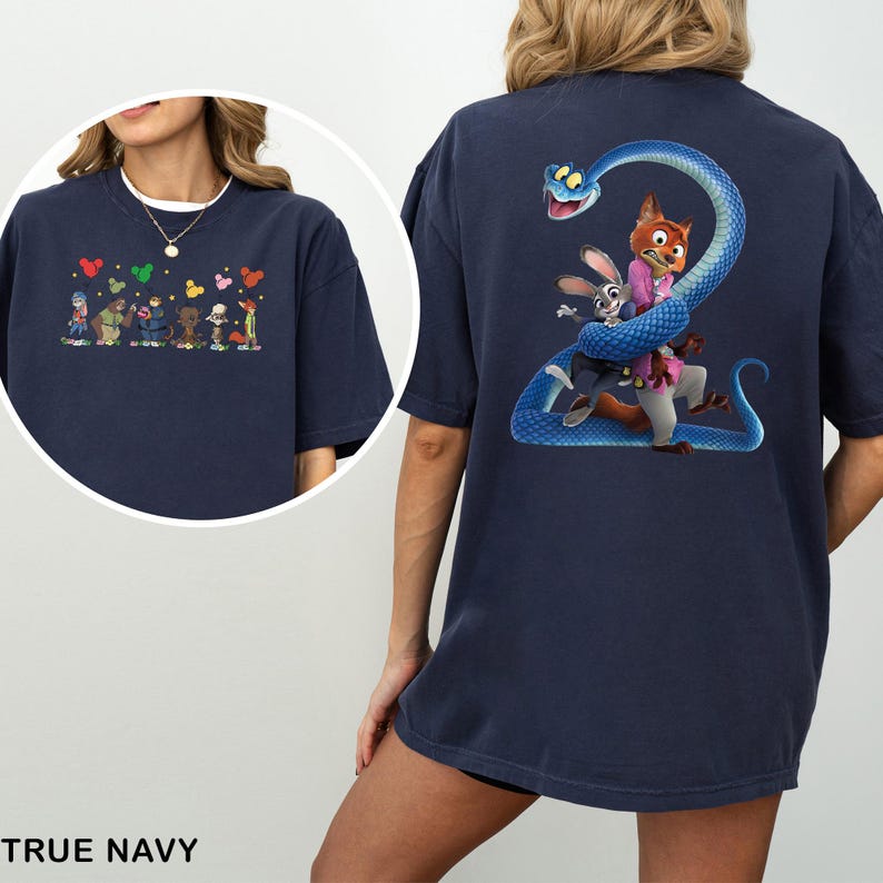 Pu&ograve; includere: T-shirt blu navy con illustrazioni di cartoni animati sul davanti e sul retro. Il davanti presenta personaggi dei cartoni animati e forme di cuore. Il retro mostra un serpente blu avvolto attorno a una volpe e un coniglio. Il testo "TRUE NAVY" &egrave; in basso.