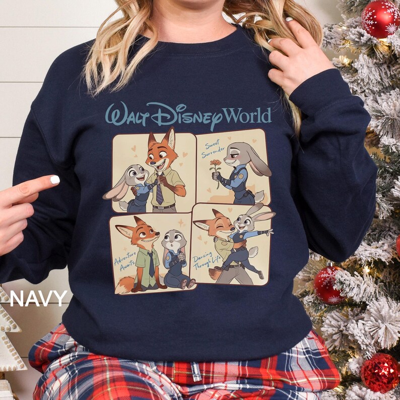 May include: Navy blue sweatshirt featuring a four-panel design with characters from the Disney movie Zootopia. The top panel has the text "Walt Disney World". The panels show Nick Wilde and Judy Hopps in various scenes. The word "NAVY" is printed on the bottom left.