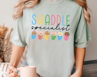 Swaddle Specialist Shirt, Comfort Colors, Labor And Delivery Nurse Shirt, NICU Nurse Shirt, Baby Nurse Shirt, Neonatal ICU Nurse Tee, 173474