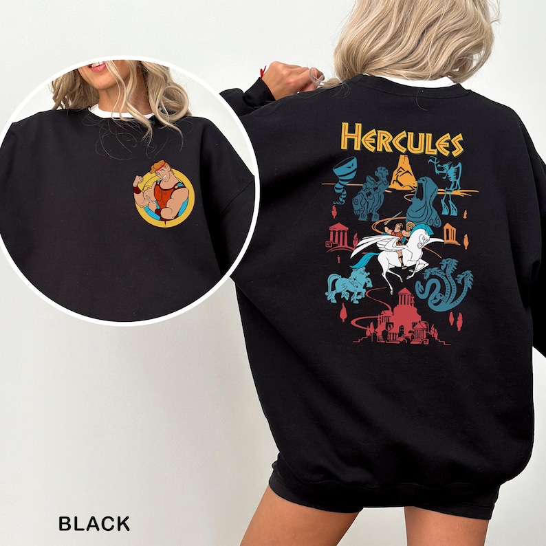 K&ouml;nnte beinhalten: Schwarzes Sweatshirt mit einem Cartoon-Motiv von Herkules auf der Vorderseite und einem gr&ouml;&szlig;eren Design auf der R&uuml;ckseite. Das R&uuml;ckendesign enth&auml;lt das Wort "Hercules" in Gold sowie verschiedene Zeichentrickfiguren und Szenen aus dem Film. Das Sweatshirt hat einen wei&szlig;en Kragen.