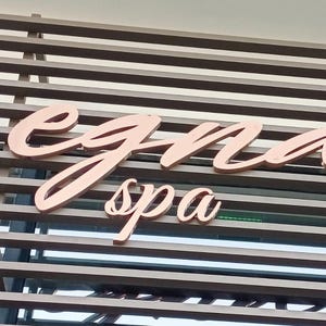 This sign is in mirrored bronze color.
mounted on a wooden background.