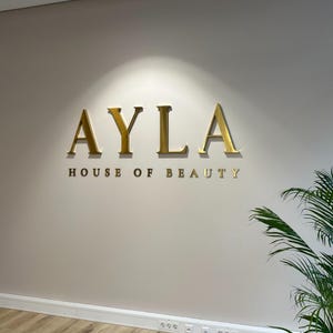 indoor sign.
made of stainless steel.
colour is brushed gold.
spaced 1 inch from wall.
letter thickness is 1 inch.