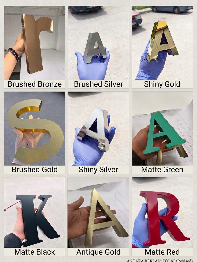 May include: A collection of nine three-dimensional letters featuring various finishes including brushed bronze, brushed silver, shiny gold, brushed gold, shiny silver, matte green, matte black, antique gold, and matte red, labeled with their respective names.