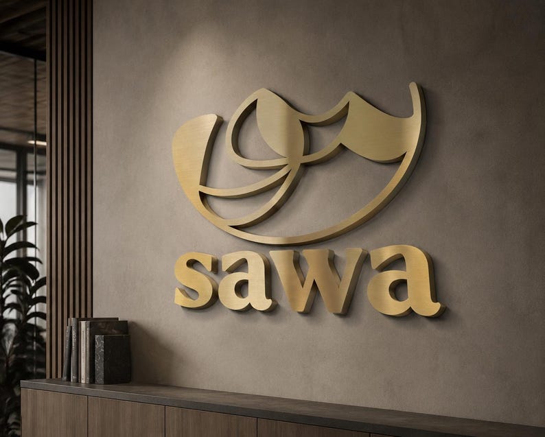 Może przedstawiać: Złote logo z napisem "sawa" w kroju pisma szeryfowego. Logo jest zamontowane na ścianie w neutralnych odcieniach. Projekt nad znakiem słownym to abstrakcyjny kształt z zakrzywionymi liniami.