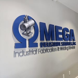 May include: A three-dimensional wall sign featuring a large blue Greek letter Omega symbol containing a silver industrial pipe icon. Next to it, the blue text reads MEGA INDUSTRIAL SERVICES, LLC, with the words Industrial Fabrication & Welding Services below.