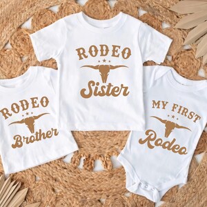 three baby onesuits with rodeo designs on them