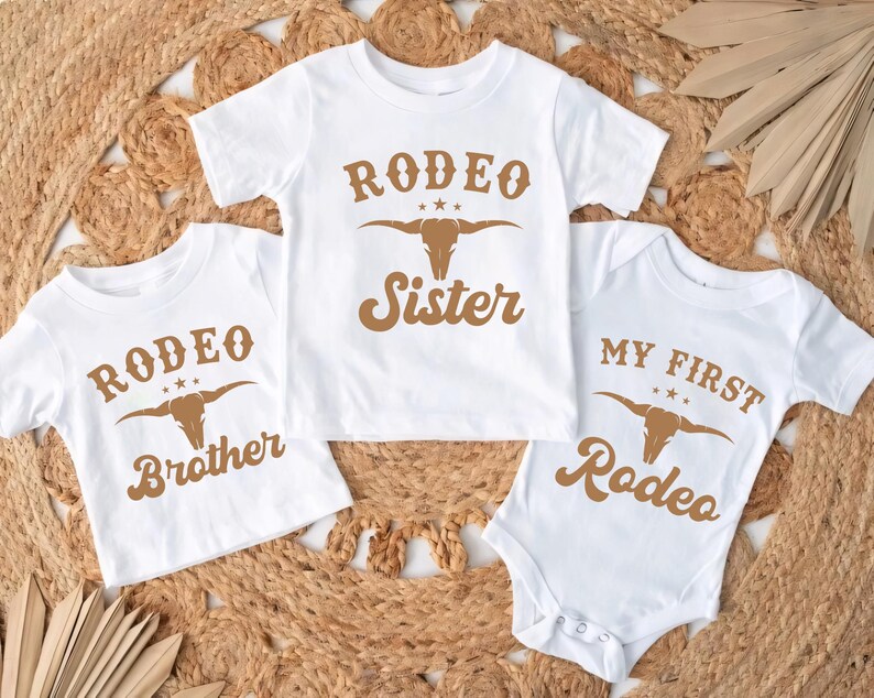 three baby onesuits with rodeo designs on them
