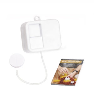 Könnte beinhalten: Weißes DIY-Spieluhr-Set mit einer weißen Zugschnur, einem weißen Knopf und einem Booklet mit Anleitungen zum Selbermachen von 10 verschiedenen Stofftieren. Der Booklet-Umschlag lautet "DIY-SPIELUHR 10 Anleitungen für Spieluhren zum selber Häkeln und Nähen".