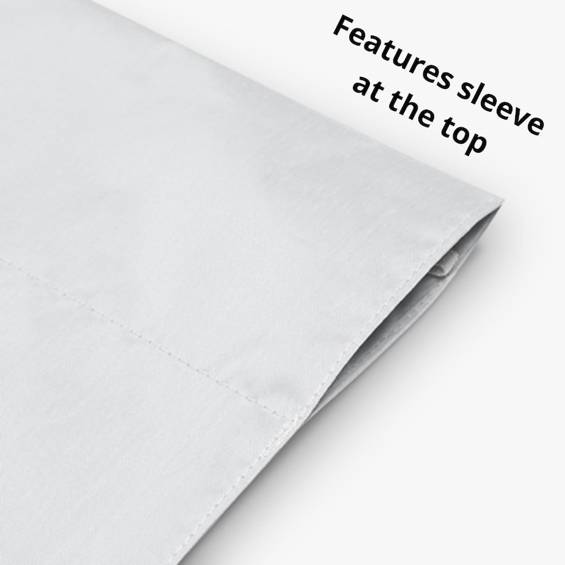 May include: A solid white fabric panel featuring a stitched sleeve at the top edge. The text "Features sleeve at the top" is printed in black on the upper right side of the white material, indicating the functional design of the textile item.