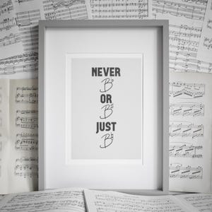 May include: A framed print with the text "NEVER B♭ OR B♯ JUST B♭" in black against a white background. The frame is gray. The background is filled with sheet music.