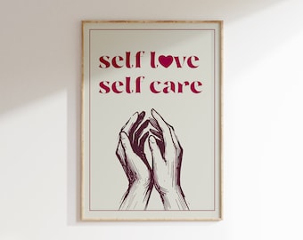 May include: A framed print with the text "self love self care" in pink lettering with a small pink heart between the words. The print features a black and white illustration of two hands clasped together.