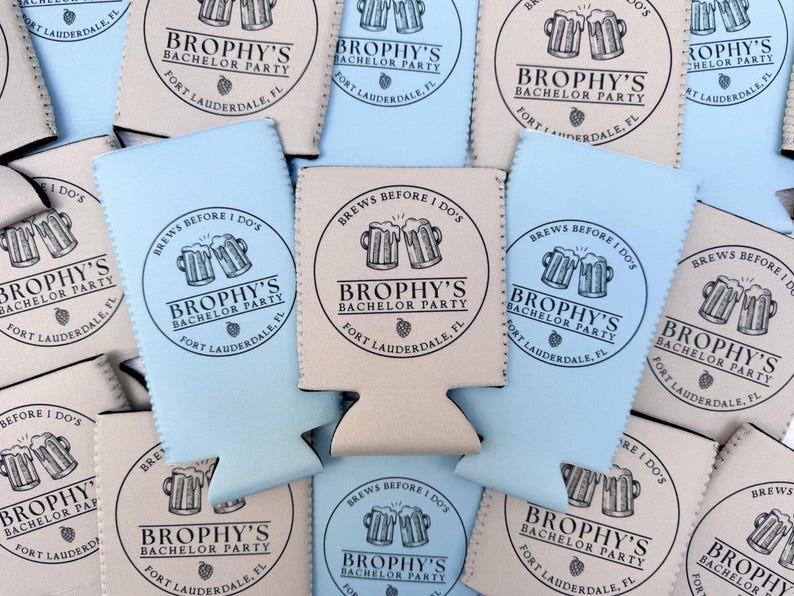 May include: A collection of beer can coolers in light blue and beige. Each cooler features the text "Brophy's Bachelor Party, Fort Lauderdale, FL" in a circular design with beer mugs. The phrase "Brews Before I Do's" is also included.