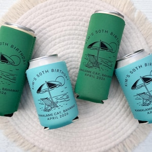 Puede incluir: Cuatro enfriadores de latas de bebidas en verde y azul, cada uno con un gr&aacute;fico de escena de playa y el texto "Kim's 50th Birthday, Kamalame Cay, Bahamas, April 2026." Los enfriadores est&aacute;n sobre una superficie tejida blanca.