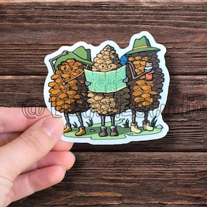 May include: Three cartoon pine cones wearing hats and backpacks are holding a map and looking at it. The pine cones are brown and green and have smiling faces.