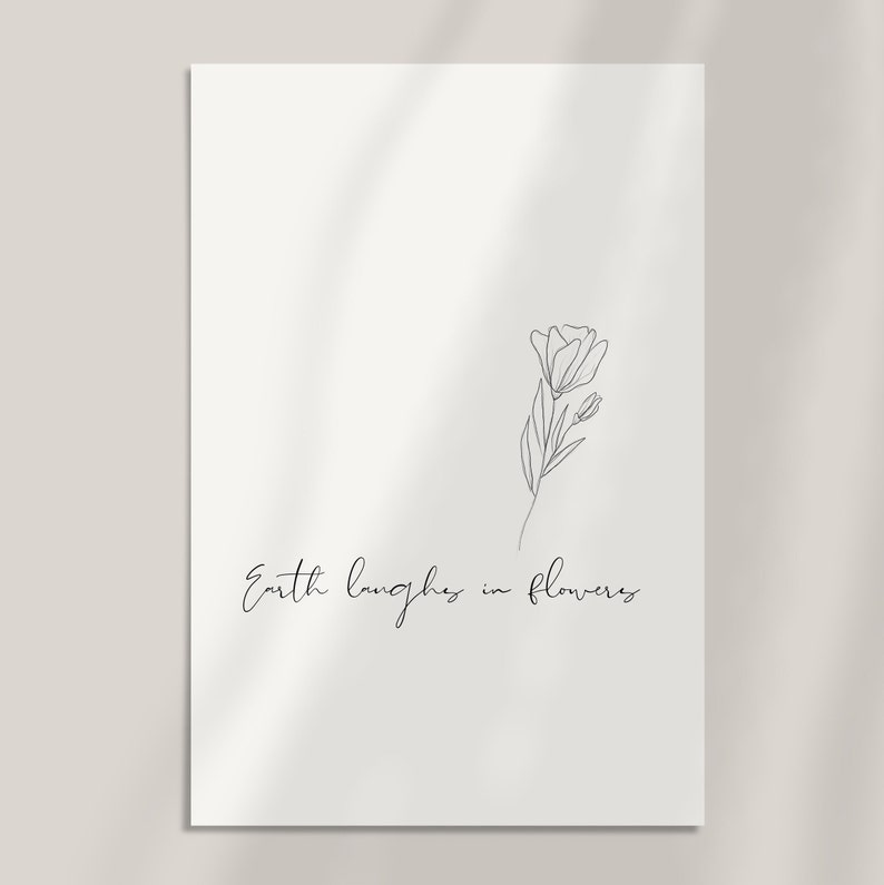 May include: A black and white line drawing of a flower with the text "Earth laughs in flowers" below it.