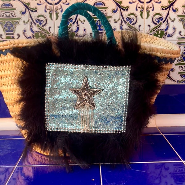 Capazo con tela azul de glitter y plumas. Estrella central con strass.