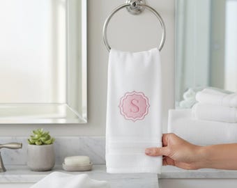 May include: White hand towel with a pink embroidered initial "S" in a decorative frame. The towel is hanging on a chrome towel ring in a bathroom setting. The text "FITS MY FANCY HANDCRAFTED" is at the top.
