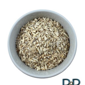 May include: A white bowl filled with dried, light brown, and beige, shredded plant material.